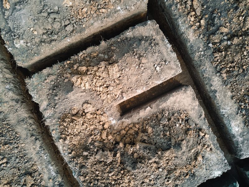 Ausgegrabener Graben für Bauarbeiten des neuen Hausbetonfundaments auf der Baustelle